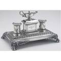Victorian silver desk standish by e  j bernard london 1858 the central lidded chamber with serpenthandled lamp flanked by a pair of gadrooned inkwells on rectangular base with paw feet inscribe