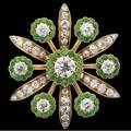 Diamond and demantoid starburst brooch fine oec diamond approx 85 cts and six oec diamonds 15 cts tw centering floriform clusters of demantoid garnets alternated with diamond set leaves 14k p
