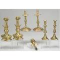 Brass candlesticks grouping of seven 18th c pair with drip cups 19th c pushup sticks one with a peg lamp heavy pair of 20th c sticks with lions head decoration tallest 10 34