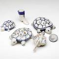 Dedham crackleware six small items three turtle flower frogs a boot a nude spoon rest and a button turtles have indigo stamps largest turtle 5 14 large turtles one has reglued leg other h
