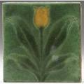 Grueby tile decorated in cuenca with a yellow tulip and green leaves on a green ground two corner chips marked ky 6 sq