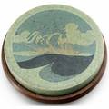 Marblehead circular trivet tile decorated in waxresist with a tall ship on indigo and green waves against green clouds complete with a fitted wooden stand from the collection of arthur baggs daug