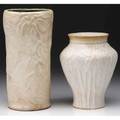 Tiffany two vases embossed with foliate designs on white bisque ground smaller with chipping at rim and base both have incised marks 7 34 and 6