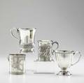 Four silver cups by tiffany  co 18851900 cylindrical brightcut with neoclassical motif 3 cylindrical with flared foot and rim depicts cherubs playing ice skating or swimming among foliage 3