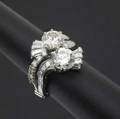 Art deco diamond and platinum bypass ring two circular transitional cut diamonds each approx 2 cts accented by fans and ribbons of baguette and circular cut diamonds approx 1 ct tw ca 1935