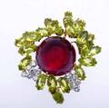 Spectacular gemset brooch 18k yg and platinum with round cabochoncut rubelite 20mm nestled among sprays of marquiseshaped peridots and fine brilliant cut diamonds approx 180 cts tw ca 1960