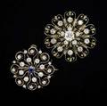 Two diamond  gold brooches both of circular scroll designs 14k yg one with a sapphire and omc diamonds approx 150 cts 1 18 one with principal omc diamond approx 110 cts and 160 cts s