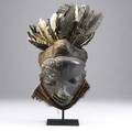 Pende mbangu mask zaire africa carved wood with black and white painted face and attached raffia grass headdress adorned with feathers traditionally used to ward of illness in the village provena