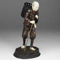 Japanese wood carving with ivory head feet and hands 20th c depicts a man carrying a basket with walking stick signed 15 34