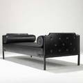 Jacques adnet daybed covered in stitched black leather with brass hardware and two bolster cushions 27 x 28 x 75