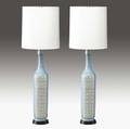 Guido gambone pair of tall ceramic table lamps with panels of alternating geometric forms in green on a white and blue ground with cylindrical linen shades one marked with partial paper label potte