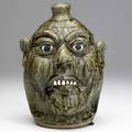 Lanier meaders face jug with smiling expression and clay teeth covered in alkaline glaze signed lanier meaders 9 12