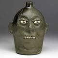 Lanier meaders face jug with granite teeth and matte and glossy dark green glaze signed lanier meaders 10 12 x 8