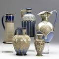 Doulton lambeth five stoneware pitchers two decorated with spriggedon blossoms and beading on guilded swirled ground one silicon and two others all marked tallest 9