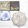American encaustic tiling co etc four tiles three by aetco a floral trivet a tile with frog and tile decorated in squeezbag with rooster and a tile by mosaic tiling co with fishing vessel in th
