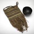 Tribal items phillippino carved wooden bowl with twine strap early 20th c kenya potato bag woven grass with fringe and strap handle mid20th c largest 22 x 7 12 dia