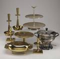 Tommi parzinger  dorlyn silversmiths  mueckcary eight assorted metal pieces seven by dorlyn silversmiths two pairs of candlesticks a covered casserole dish with glass insert and a tazza all in