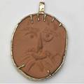 Picasso  madoura red clay pendant impressed with face in yellow gold setting alain ramie number to be added limited edition 205500 stamped madoura empreinte originale de picasso and marked 205