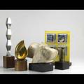 Seven contemporary sculptures brass bronze marble and mixed media forms each mounted on a display base together with a decorative painting largest 24 on a 36 wooden display pedestal