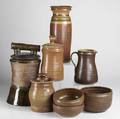 Eric cushing eight pieces of stoneware include three covered jars one with faux bois handle tall vase pitcher and three bowls tallest 15