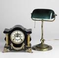 Desk accessories ansonia black metal mantle clock with open escapement time and strike movement together with an emeralite desk lamp with a brass base and green case glass shade signed each early 20