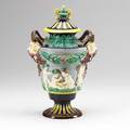 Majolica covered urn with cherub design and mask head with horns for handles 19th c base hairlines and repair double fish stamp 13 12