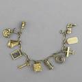 Figural gold charm bracelet fetter chain suspends eleven charms 14k yg including biplane hourglass safe telephone sailboat etc ca 1940 246 gs gw 7