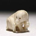 Japanese ivory netsuke depicting a dog with inlaid eyes licking his right hind paw 20th c signed ikku 1 38 x 1 34