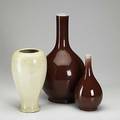 Three chinese vases two oxblood gourdshaped vases together with a cream colored drilled vase 19th20th c tallest 15
