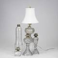 Oil lamps and accessories eleven pieces three whale oil lamps with brass collars pair of thumb hold lamps guard oil lamp with bronze foot mountings etc tallest 14