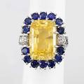 Yellow and blue sapphire ring ca 1940 rectangular cushion cut yellow sapphire 184 x 122 x 107 mm approx 2475 cts bordered by 14 circular faceted blue sapphires approx 4 cts tw and diamond