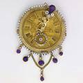 Gemset gold watch face broochpendant scenic and engineturned watch face with applied putti four diamonds 72 cts amethysts and seed pearls 404 gs 3 14 beyond festoon