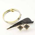 Modern gold jewelry interlocking and transferrable pair of 14k wg or yg hinged bracelets partial patinated 14k earrings with lever closure 4 14 patinated silver and gold brooch with 18 ct brilli