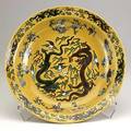 Dish with confronting dragons the interior decorated with an incised outline enclosing two fiveclawed dragons in pursuit of a flaming pearl amidst clouds the exterior with four further dragons a