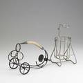 Two wine cradles one trolley in silver plate wire with wooden handle the other upright in aluminum wire larger 10 12