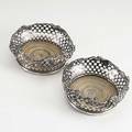 Pair of wine coasters silver pierced and punched in an x pattern with applied grapevine decoration to rim 19th20th c 5 12 dia
