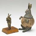 Two bronze rabbits one eating a large carrot mounted on wood base the other an inkwell mounted on a coconut shell 20th c damage to coconut shell taller 8