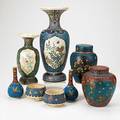 Japanese cloisonne on porcelain eight items early 20th c three vases two covered jars and two lidless jars tallest 12