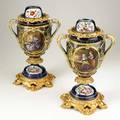 Pair of continental porcelain urns handpainted figural decoration with gilt bronze mounts 20th c unmarked 16 x 10