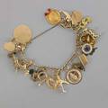 Gold charm bracelet 10k yg link chain suspends twenty travel or sentimental charms most 14k many from je caldwell some 18k some 10k mid 20th century 244 dwt gw 38 gs gw