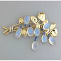 Tiffany  co moonstone and sapphire corsage ornament ca 1945 stylized bicolor 14k gold foliage set with moonstone and montana sapphire blossoms bound by platinum diamond ribbon marked 14k tiffan