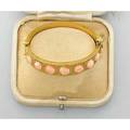 Archeological revival gold and coral bracelet ca 1880 hinged bracelet with 7 round coral cabochons precise granulation and applied wire work bloomed 18k gold in original box unmarked 163 dwt