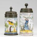 Two 18th c faience steins both with pewter lids one with bearded figure the other with bird decoration taller 8 38