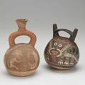 Peruvian stirrup vessels one with painted mask decoration ca 1400 one with neck damage taller 7 34