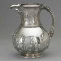 Tiffany  co silver water pitcher 1857 designed by john  edward moore bulbous body raised and chased lily and papyrus leaf decorations bead chapter and similar neck mask spout fluted handle to