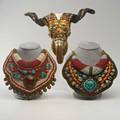 Tibetanthree pieces 20th c two ladakh gorgets set with carnelian turquoise coral and pearlsrams skull decorated with various metalsskull 10 x 13x 5