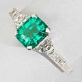 Tiffany  co emerald and diamond ring bright stepcut emerald 128 cts by formula flanked by half moon and square cut diamonds approx 50 ct tw in platinum ca 1950 2 dwt 32 gs size 4