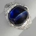 Art deco sapphire cabochon and diamond ring chatoyant blue sapphire 113 cts with circular and baguette cut diamonds approx 50 cts carved and milgrained platinum setting ca 1930 55 dwt