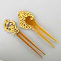 Two goldmounted horn combs ca 1900 both ornamental in the rococo style one enameled 18k yg with nineteen prongset oec diamonds on openwork lattice approx 95 ct tw one with pierced 14k yg