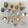 Sixteen insect or scarab stick pins 19th20th c nine gold examples include faience or nephrite scarabs diamonds pearls rubies sapphire gorham silver stag beetle two natural scarabs fish vert